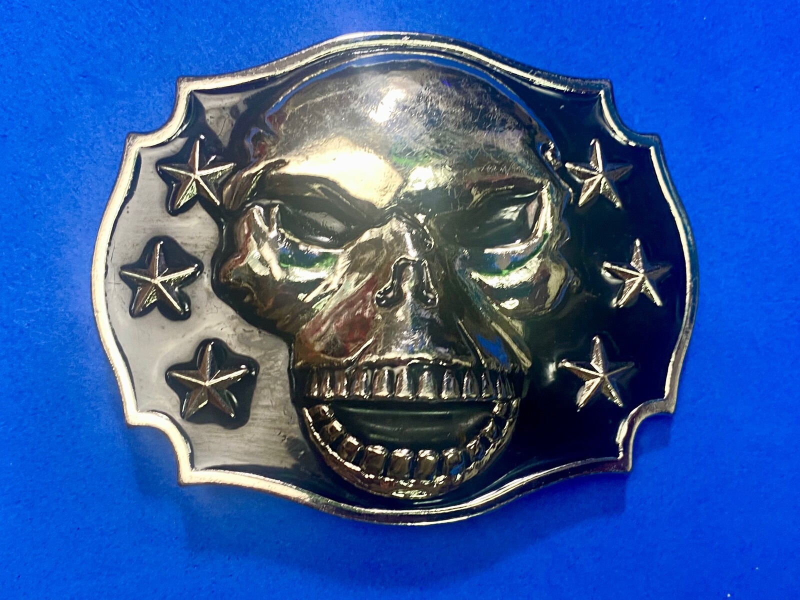 Raised Skull With Teeth Grin Black And Silver Color Belt Buckle Star Surround