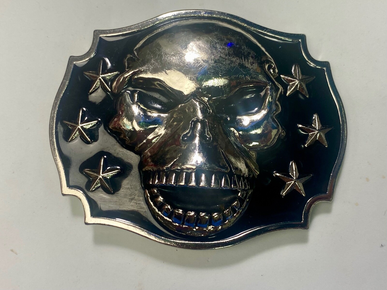 Raised Skull With Teeth Grin Black And Silver Color Belt Buckle Star Surround