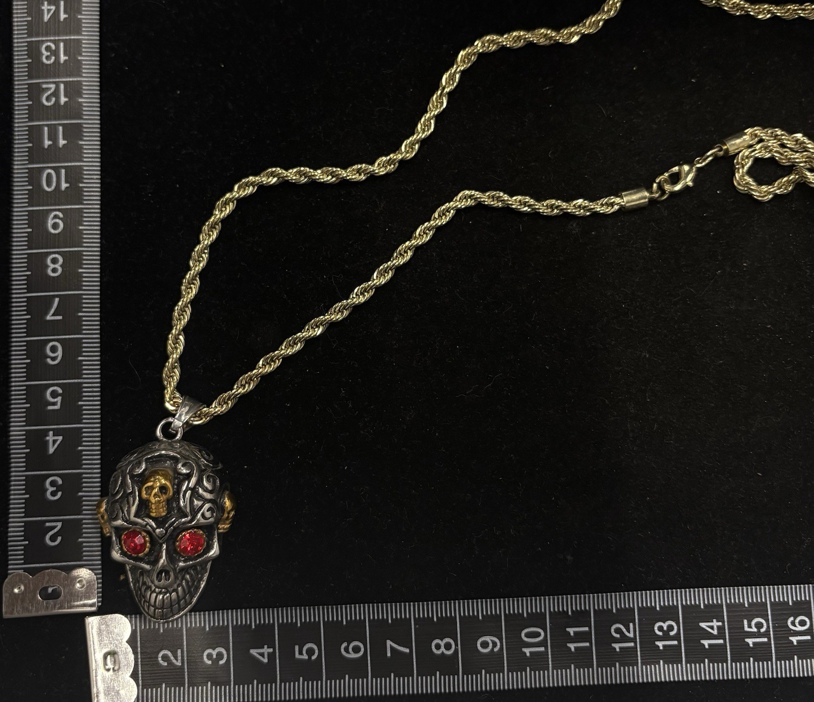 gold rope chain necklace features a gothic skull pendant with red stone eyes