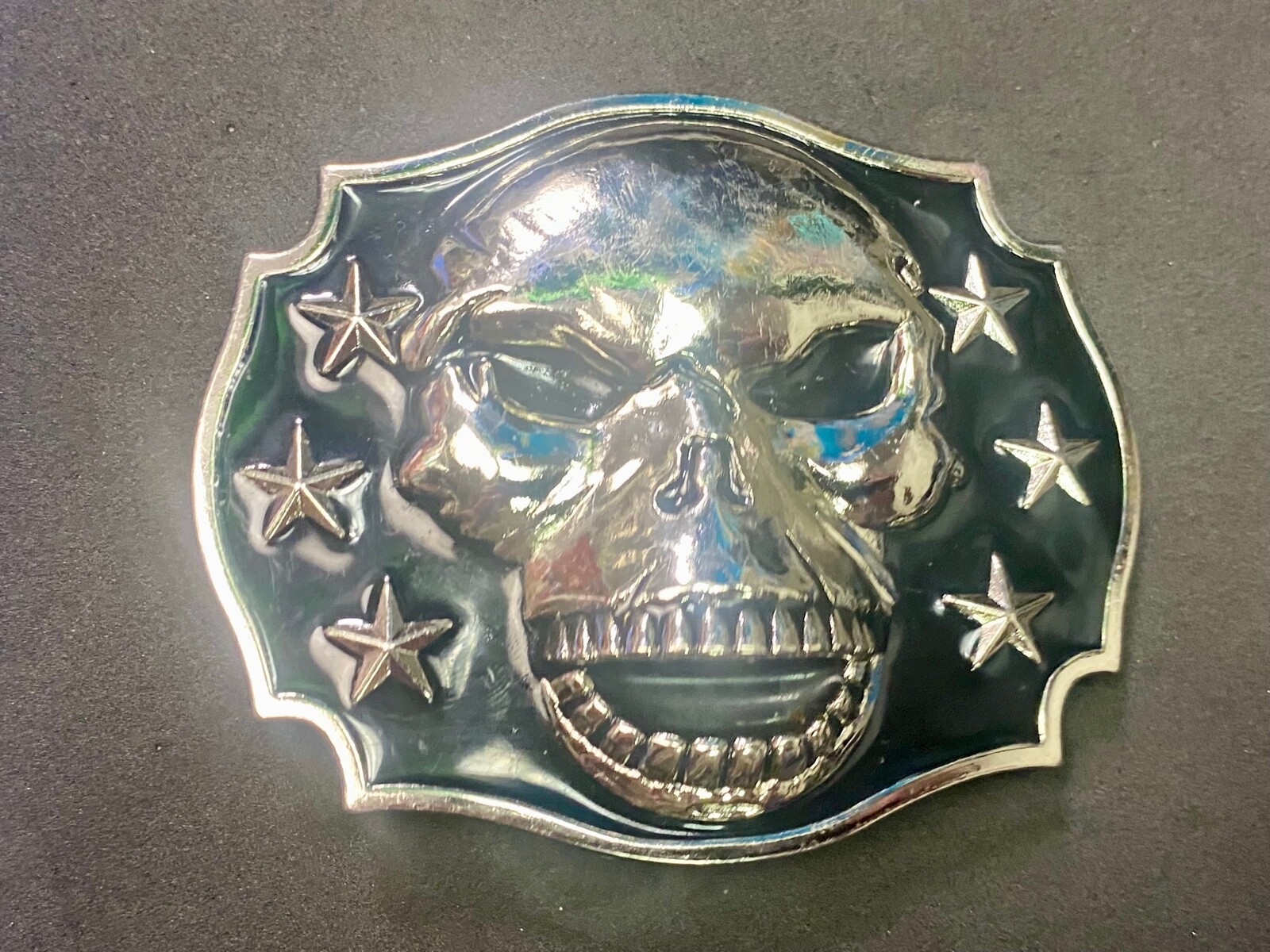 Raised Skull With Teeth Grin Black And Silver Color Belt Buckle Star Surround