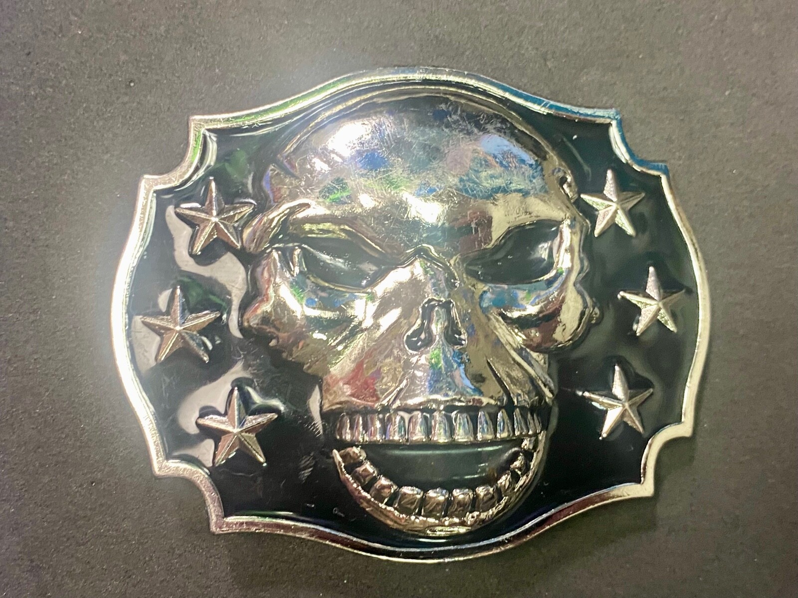 Raised Skull With Teeth Grin Black And Silver Color Belt Buckle Star Surround
