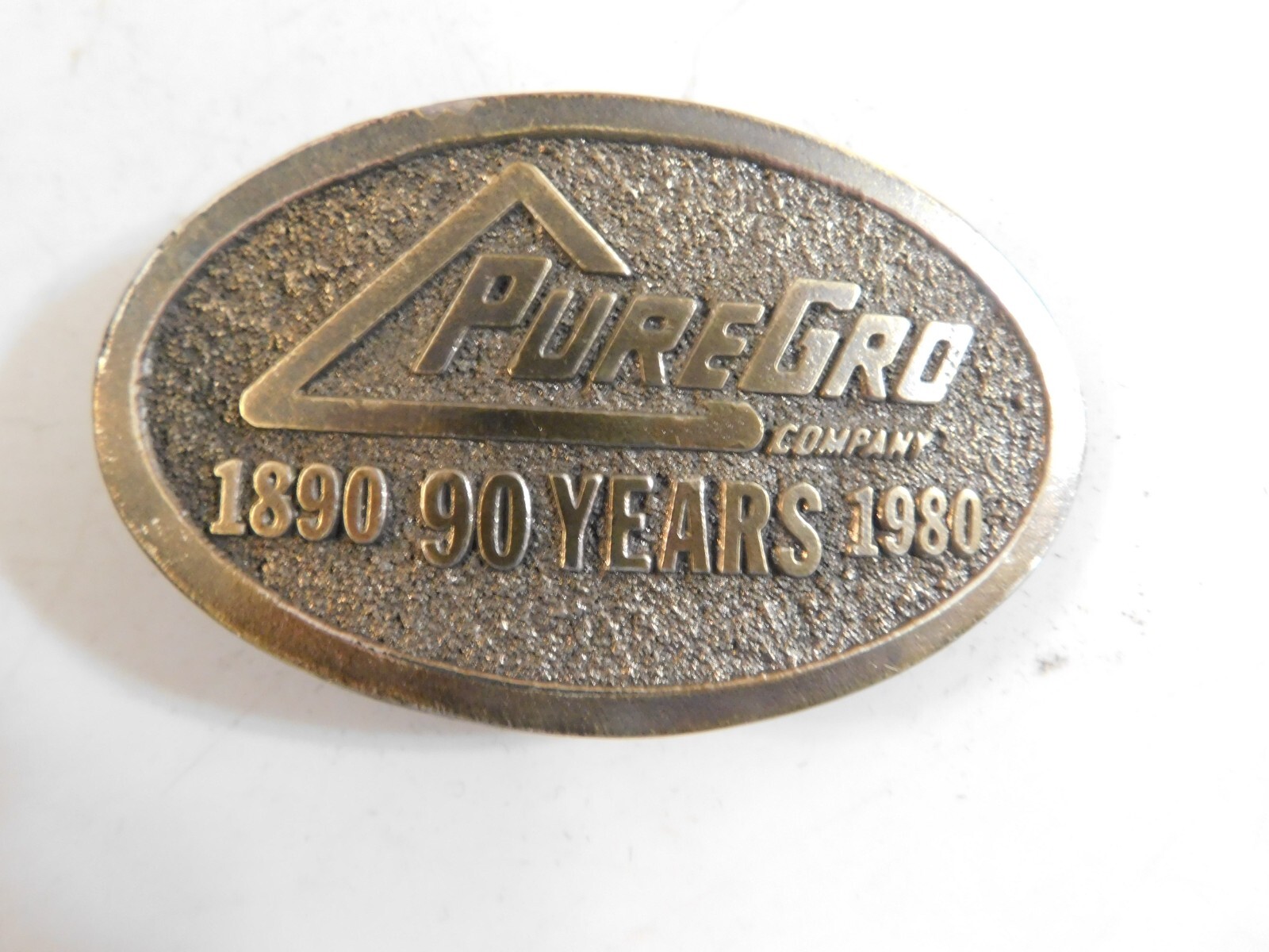 1980 PURE GRO BELT BUCKLE BY THE GREAT AMERICAN BUCKLE CO. BRASS