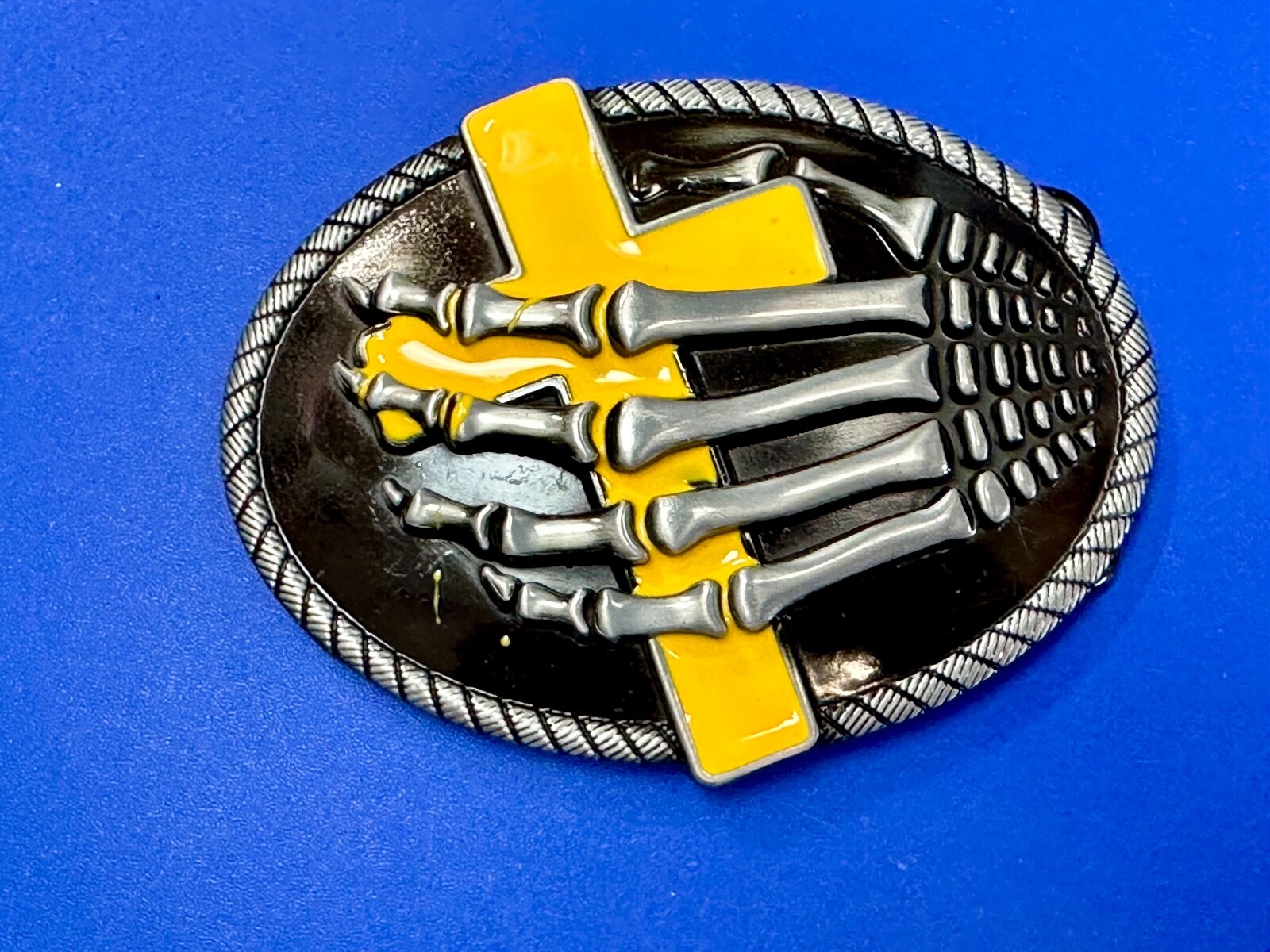 Skeleton Hand Holding Yellow Cross Vintage Dimensional Raised Belt Buckle