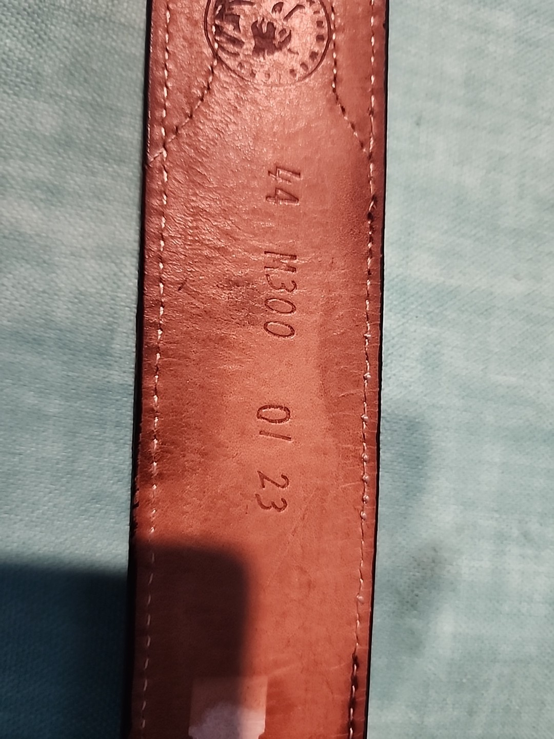 Western belt in basketweave texture featuring floral-engraved buckle in…