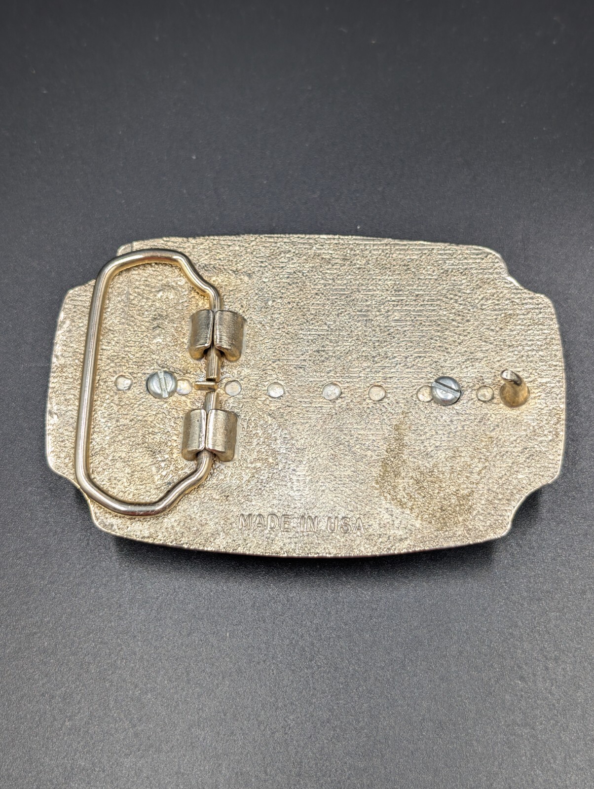 Black in lay silver toned belt buckle with marbled faux stone outlined is raised