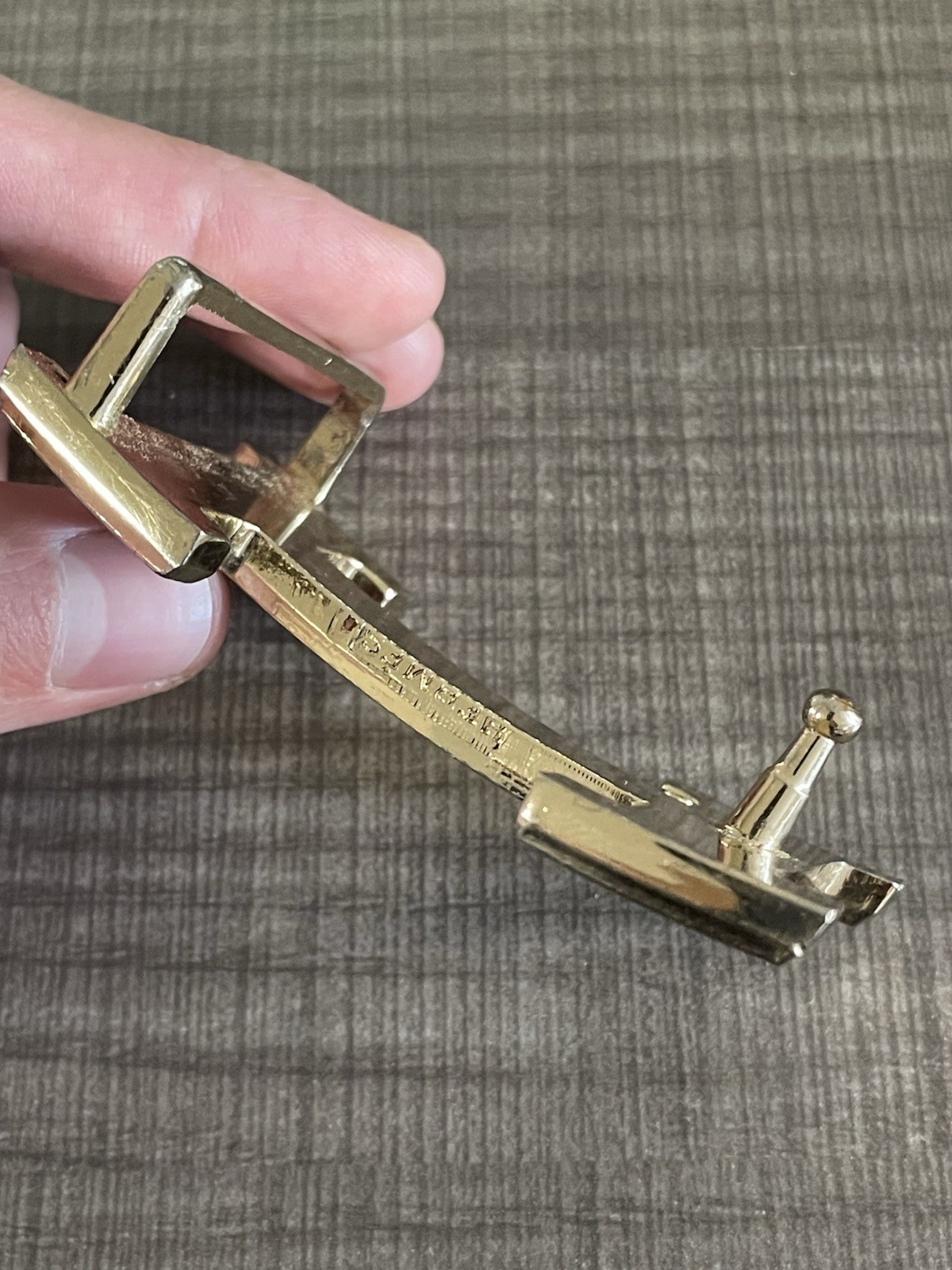 This is a gold-plated Hermès H Quizz belt buckle featuring a black lacquer inlay