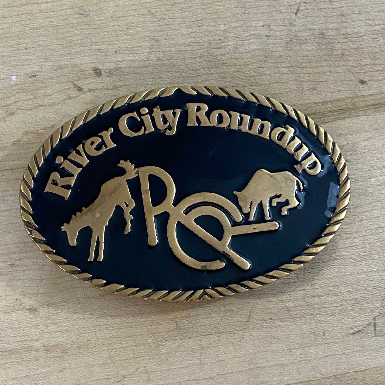 Vintage 1982 River City Roundup Belt Buckle Tapco Gold Tone Black Enamel Rodeo