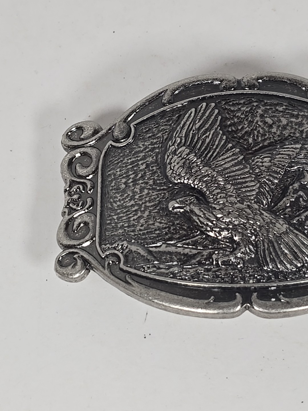 Silver Tone Belt Buckle With Eagle In Flight Against A Mountain Backdrop