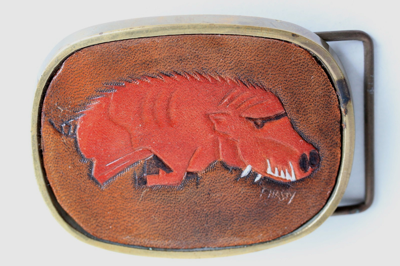 Vintage solid brass belt buckle with leather hog insert, artist signed C. Hasty