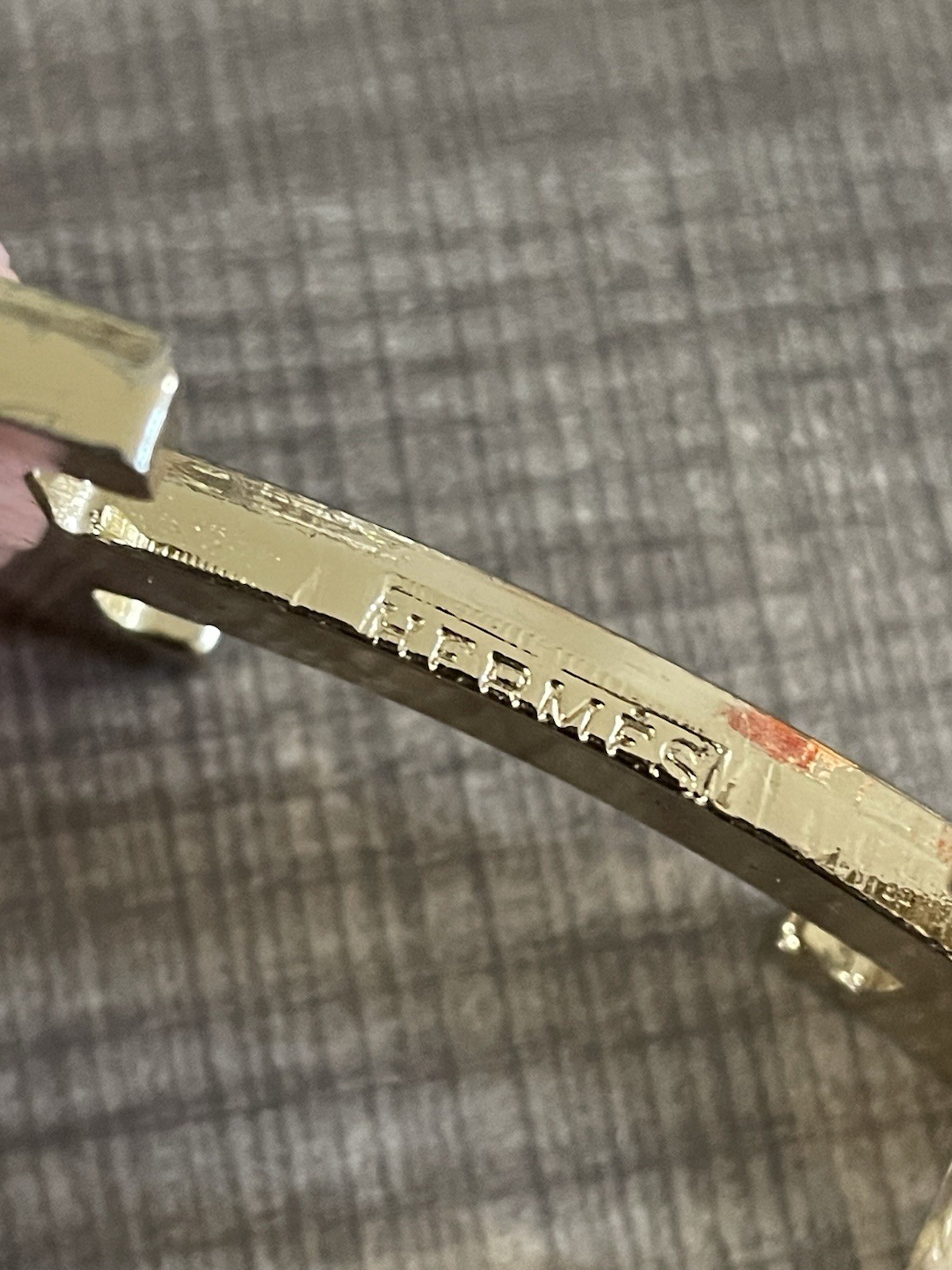 This is a gold-plated Hermès H Quizz belt buckle featuring a black lacquer inlay