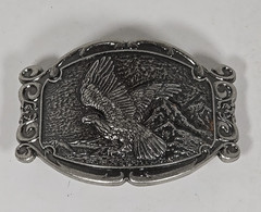 Silver Tone Belt Buckle With Eagle In Flight Against A Mountain Backdrop