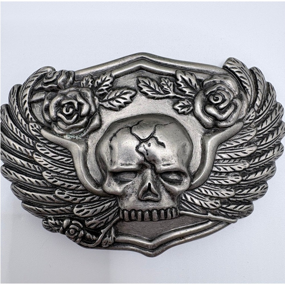 Silver-tone belt buckle featuring a skull with wings and roses