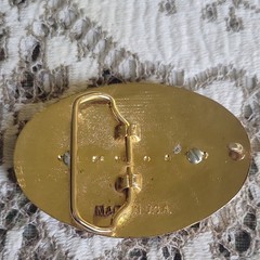 Vntage, gold-toned oval belt buckle features 1987 Canadian One Dollar Coin