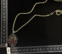 gold rope chain necklace features a gothic skull pendant with red stone eyes