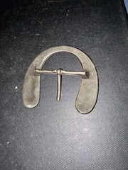 This vintage-style, handmade steel belt buckle is shaped like a horseshoe