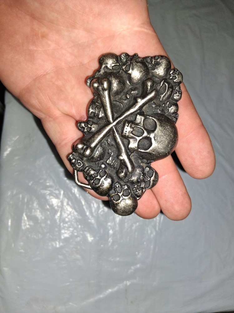 unbranded gothic belt buckle features a 3D pile of skulls and crossed bones…