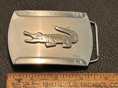Silver-toned metal belt buckle, embossed crocodile logo and « ITALY »