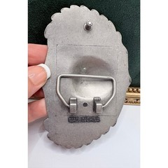 Silver-tone belt buckle featuring a skull with wings and roses