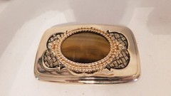 Gold rectangled belt buckle with brown oval stone