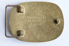 Vintage solid brass belt buckle with leather hog insert, artist signed C. Hasty