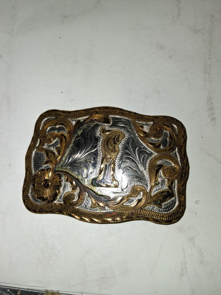 western-style belt buckle features a silver-toned textured background