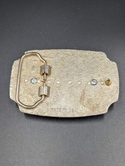 Black in lay silver toned belt buckle with marbled faux stone outlined is raised