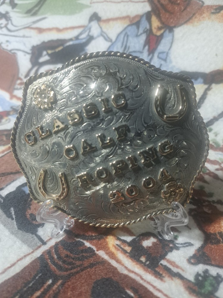Calf roping buckle, nickle silver dated 2004 with horse shoes and flowers