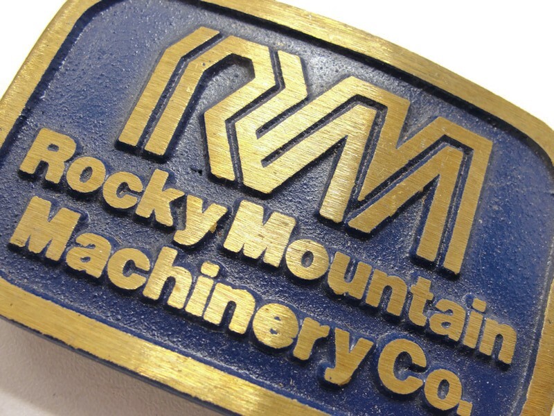 RM Rocky Mountain Machinery Co Blue & Gold Tone Belt Buckle Dynabuckle Utah