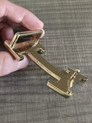 This is a gold-plated Hermès H Quizz belt buckle featuring a black lacquer inlay
