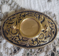 Vntage, gold-toned oval belt buckle features 1987 Canadian One Dollar Coin