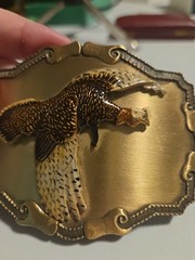 large brass colored metal belt buckle with pheasant in flight