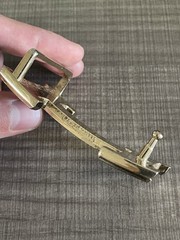 This is a gold-plated Hermès H Quizz belt buckle featuring a black lacquer inlay