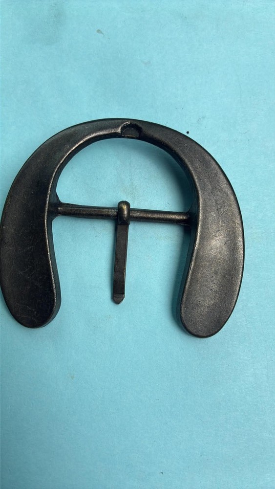 This vintage-style, handmade steel belt buckle is shaped like a horseshoe