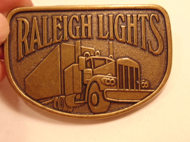 Modern brass colored advertising / trucker belt buckle: Raleigh Lights
