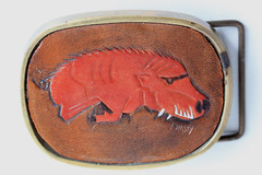 Vintage solid brass belt buckle with leather hog insert, artist signed C. Hasty