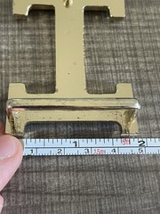 This is a gold-plated Hermès H Quizz belt buckle featuring a black lacquer inlay